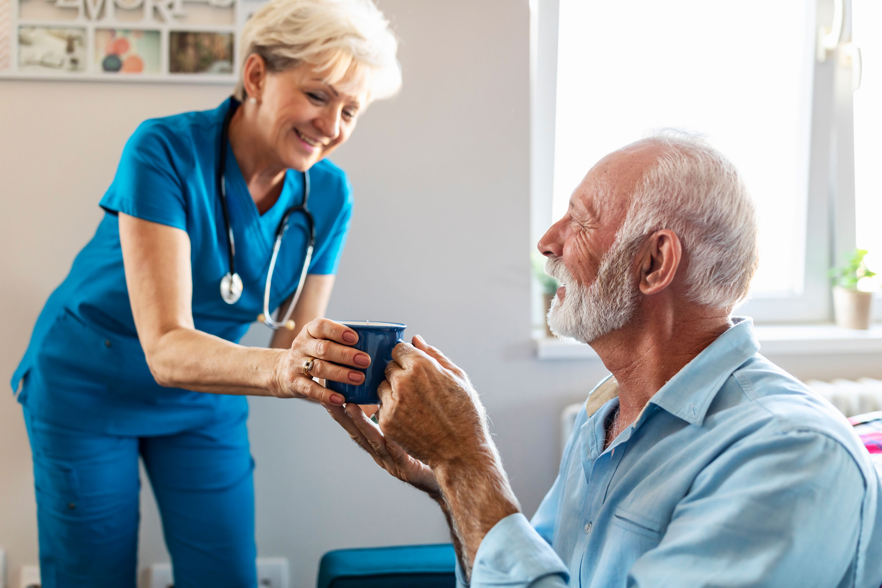 A nurse handing a man a cup of coffee