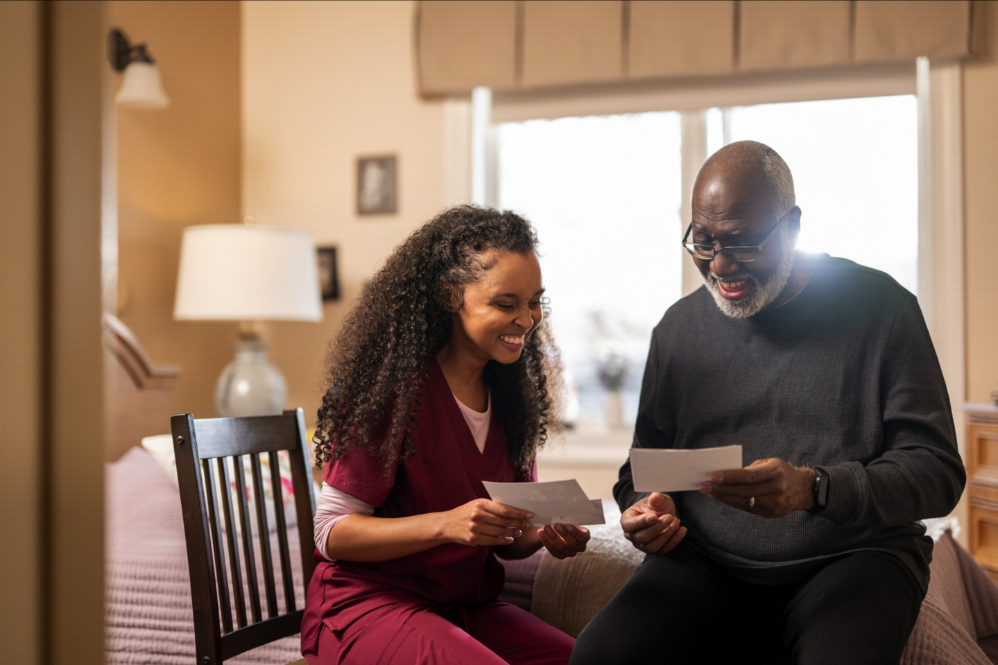 A nurse looking at pictures with a resident