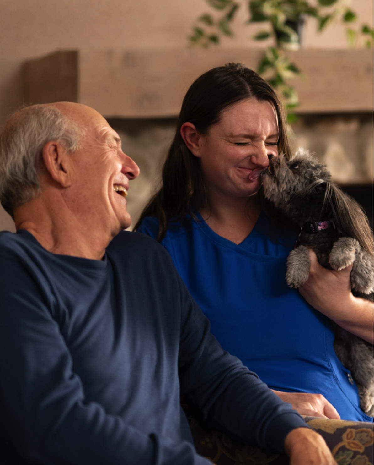 A resident and nursing playing with a dog